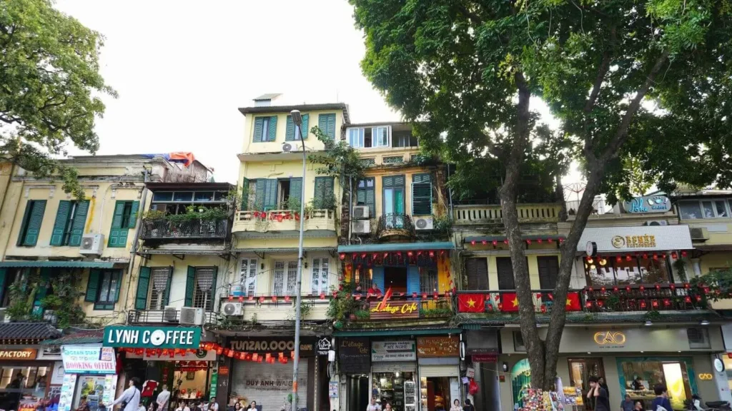 Fachadas coloniales y cafés locales en una calle del casco antiguo de Hanoi, Vietnam