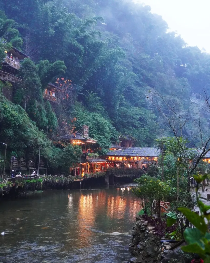 Paisaje de Cat Cat al anochecer con luces iluminando el pueblo