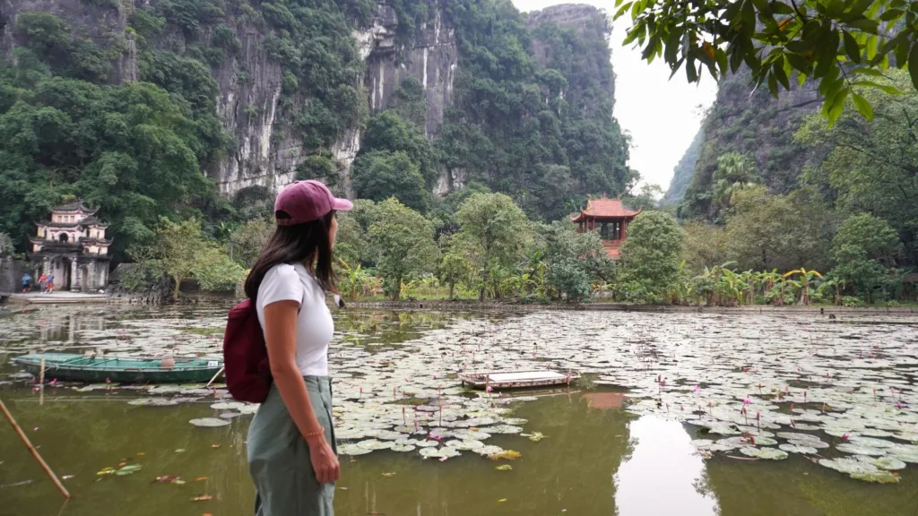 Lago con templo en Bich Dong en Ninh Binh rodeado de montañas y vegetación